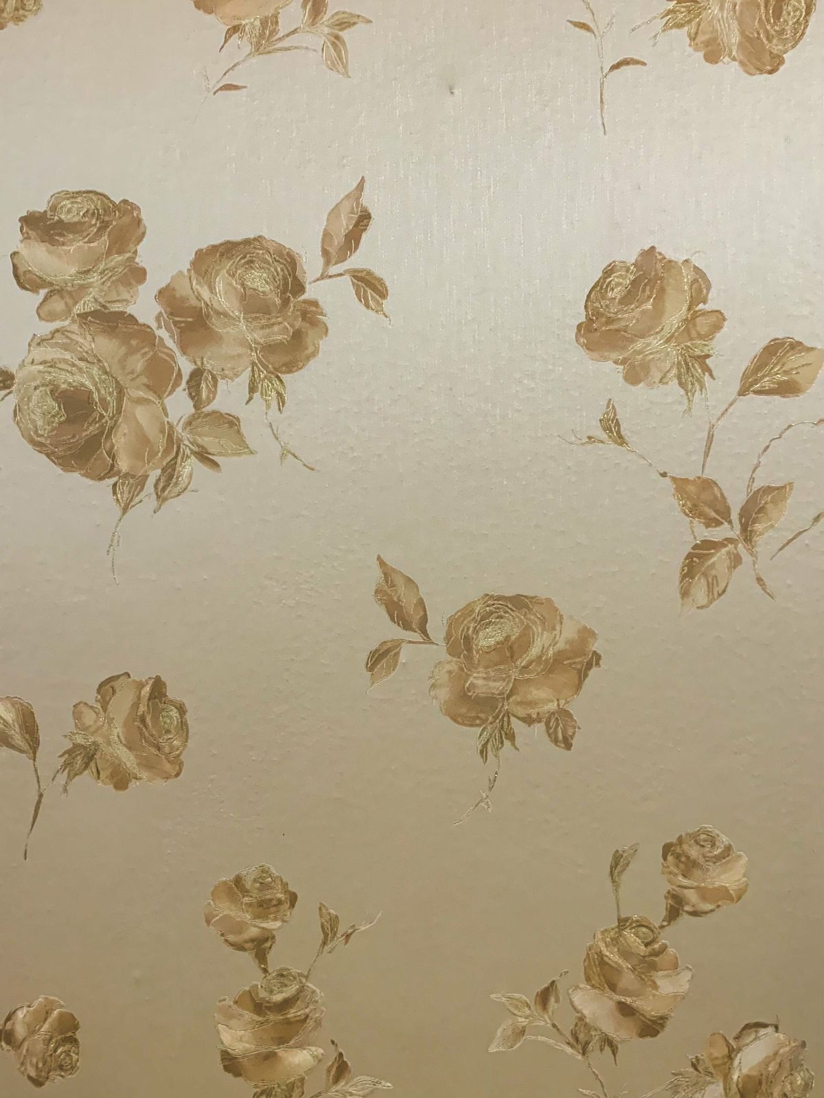 Close-up of cream wallpaper with a soft gold rose pattern